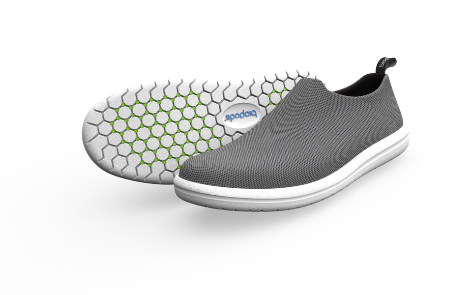Grey narrow urban sneakers by Biopods with sleek design and laces, shown from a side view.